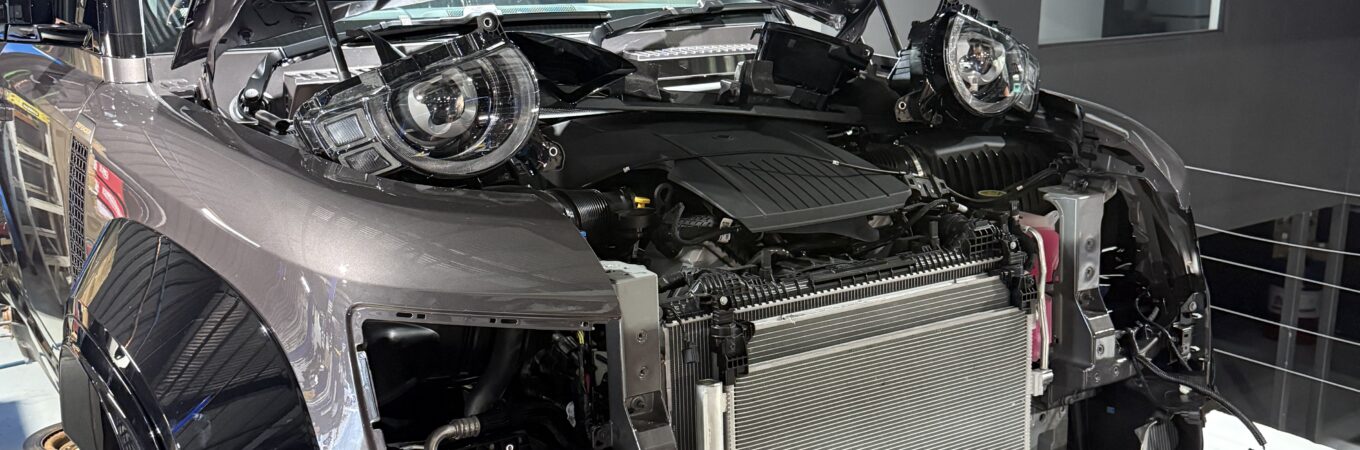 Automotive technician inspecting and repairing a car air conditioning system in a professional East Brisbane workshop to restore cooling performance.