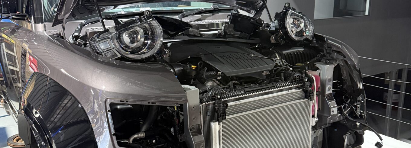 Automotive technician inspecting and repairing a car air conditioning system in a professional East Brisbane workshop to restore cooling performance.